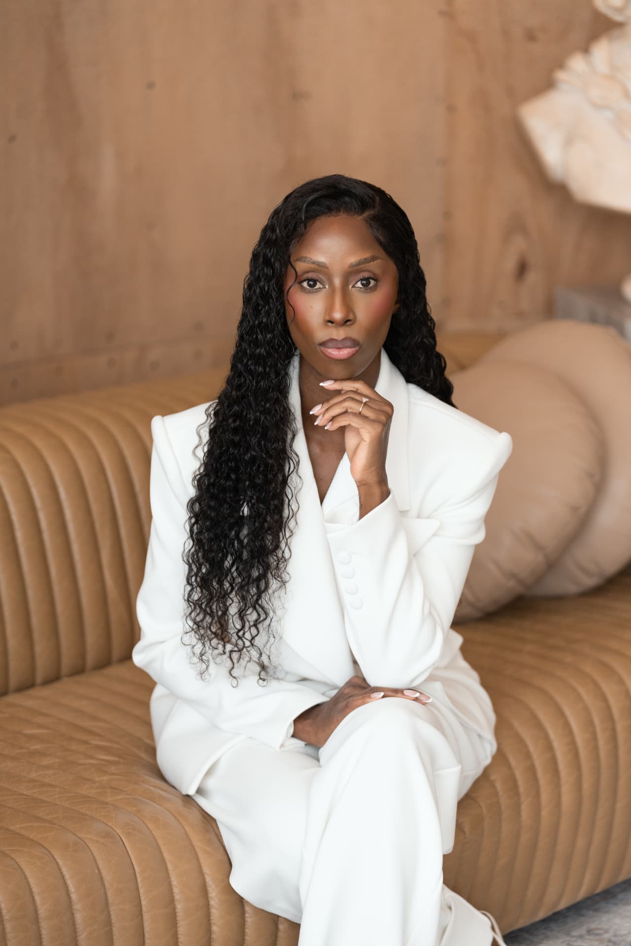 Nyambura Marincowitz seated on a tan leather couch
